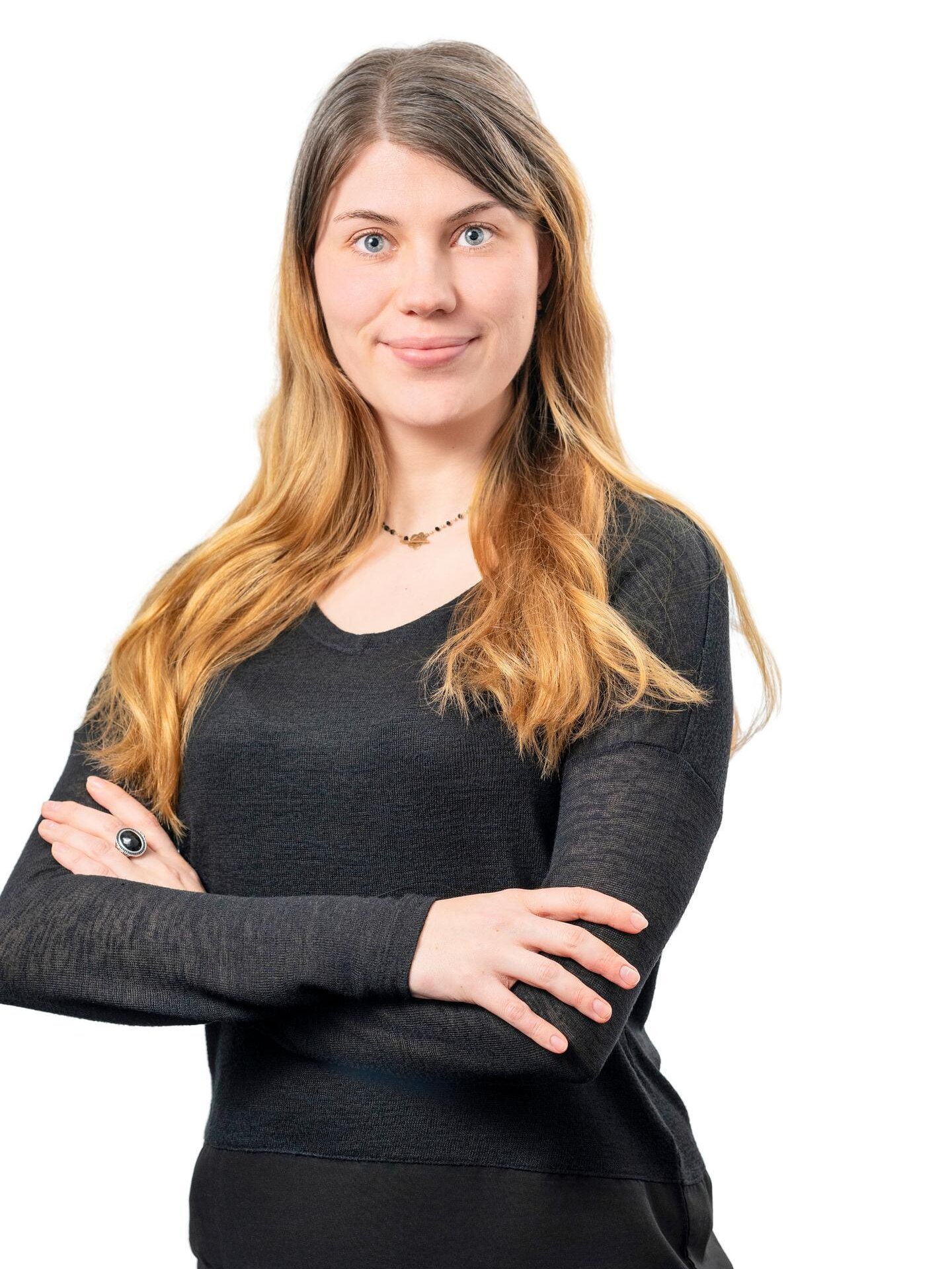 Portrait der Mieterbeirätin Julia Duwe. Sie trägt ein schwarzes Shirt, hat die Arme vor der Brust verschränkt und lacht in die Kamera.