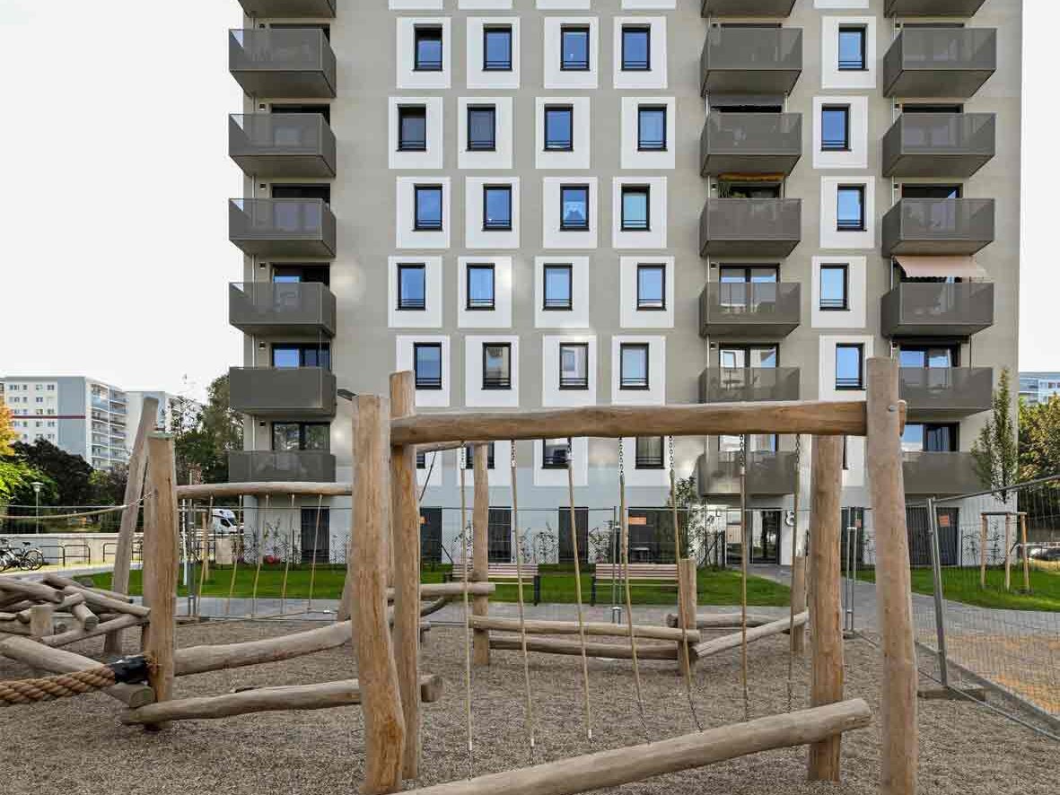 Außenansicht degewo-Neubau Max-Herrmann-Straße 8: Vorderseite mit Spielplatz im Vordergrund.