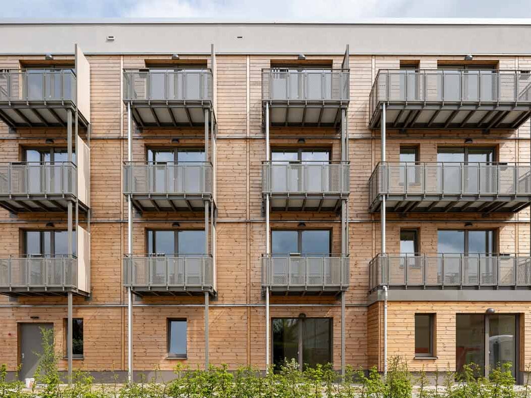 Außenansicht degewo-Neubau Beyrodtstraße 52 mit Sträuchern im Vordergrund.