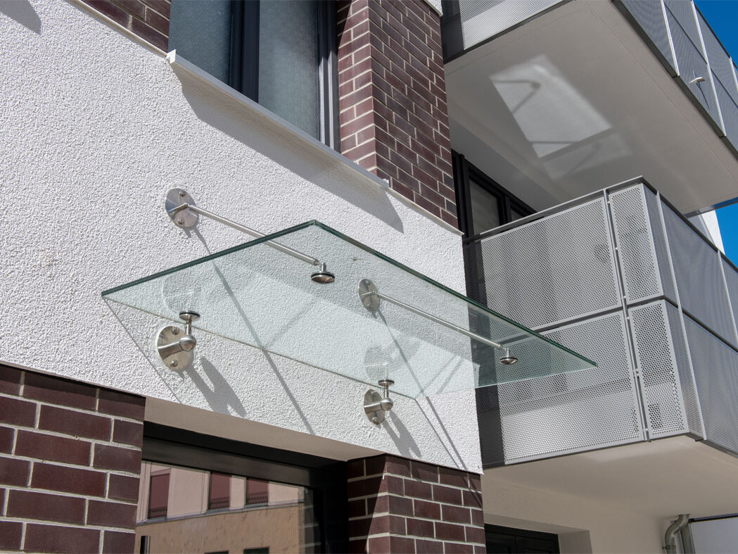 Außenansicht degewo-Neubau Lichtburgring: Fassade mit Überdachung und Balkonen.