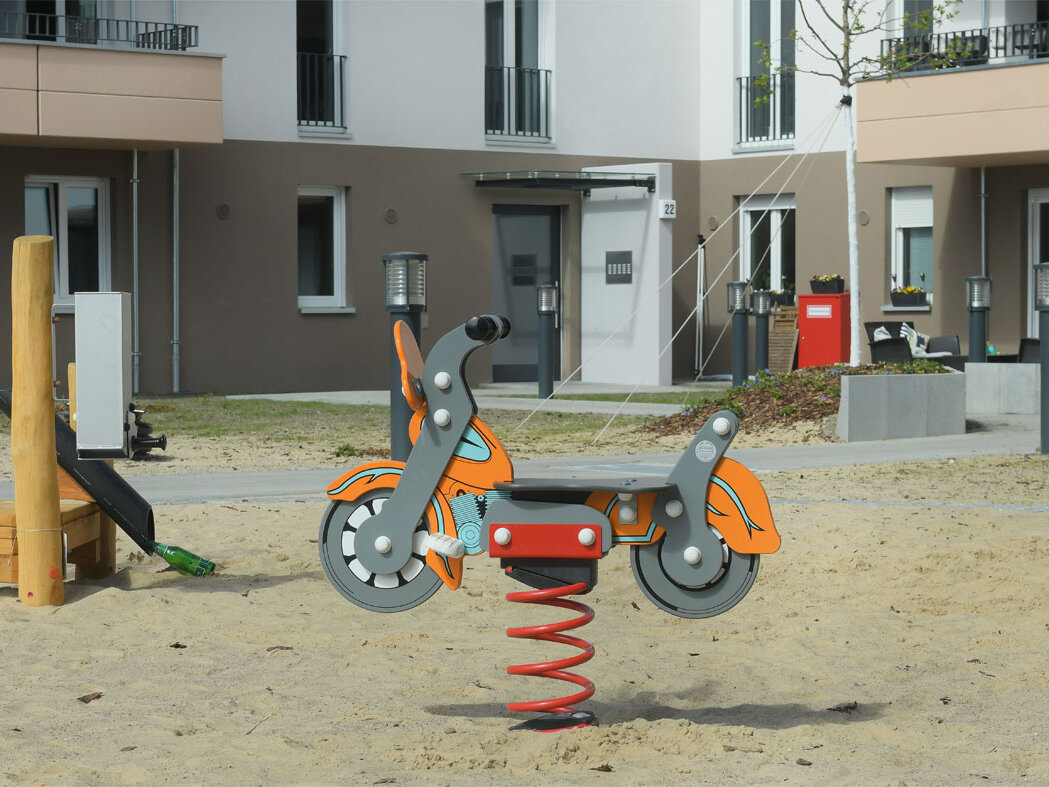 Straßenansicht degewo-Neubau Schwartzkopffstraße 20 bis 28: Hofseite mit Spielplatz im Vordergrund.