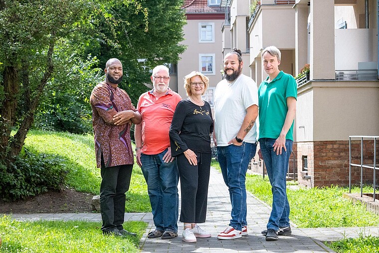 Gruppenaufnahme des Mieterbeirates im Quartier Schillerhöhe auf einer Wiese vor dem Haus.