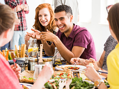 Freunde sitzen beim Essen zusammen und lachen