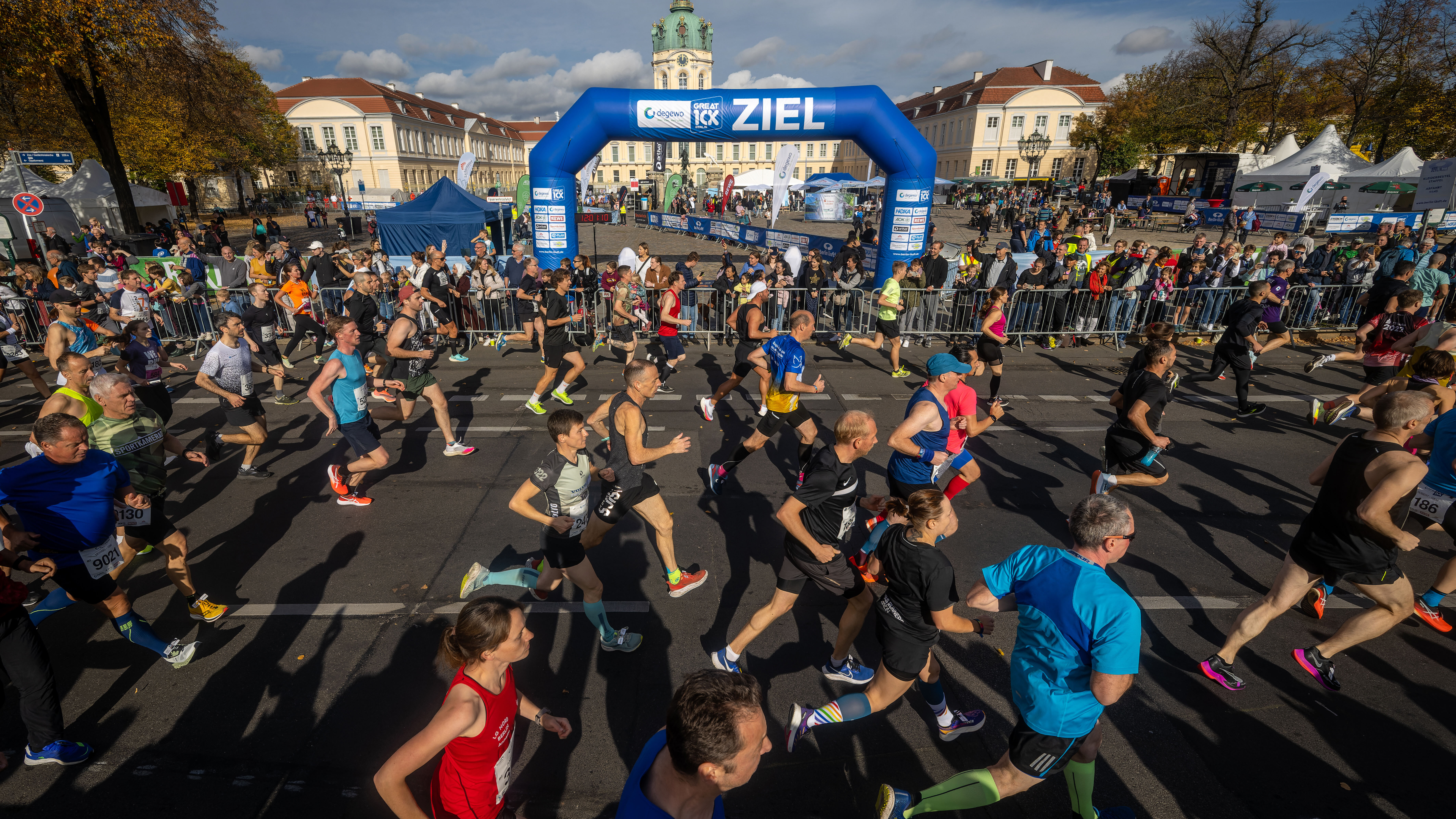 Läuferinnen und Läufer passieren Zielbogen bei Stadtlauf.
