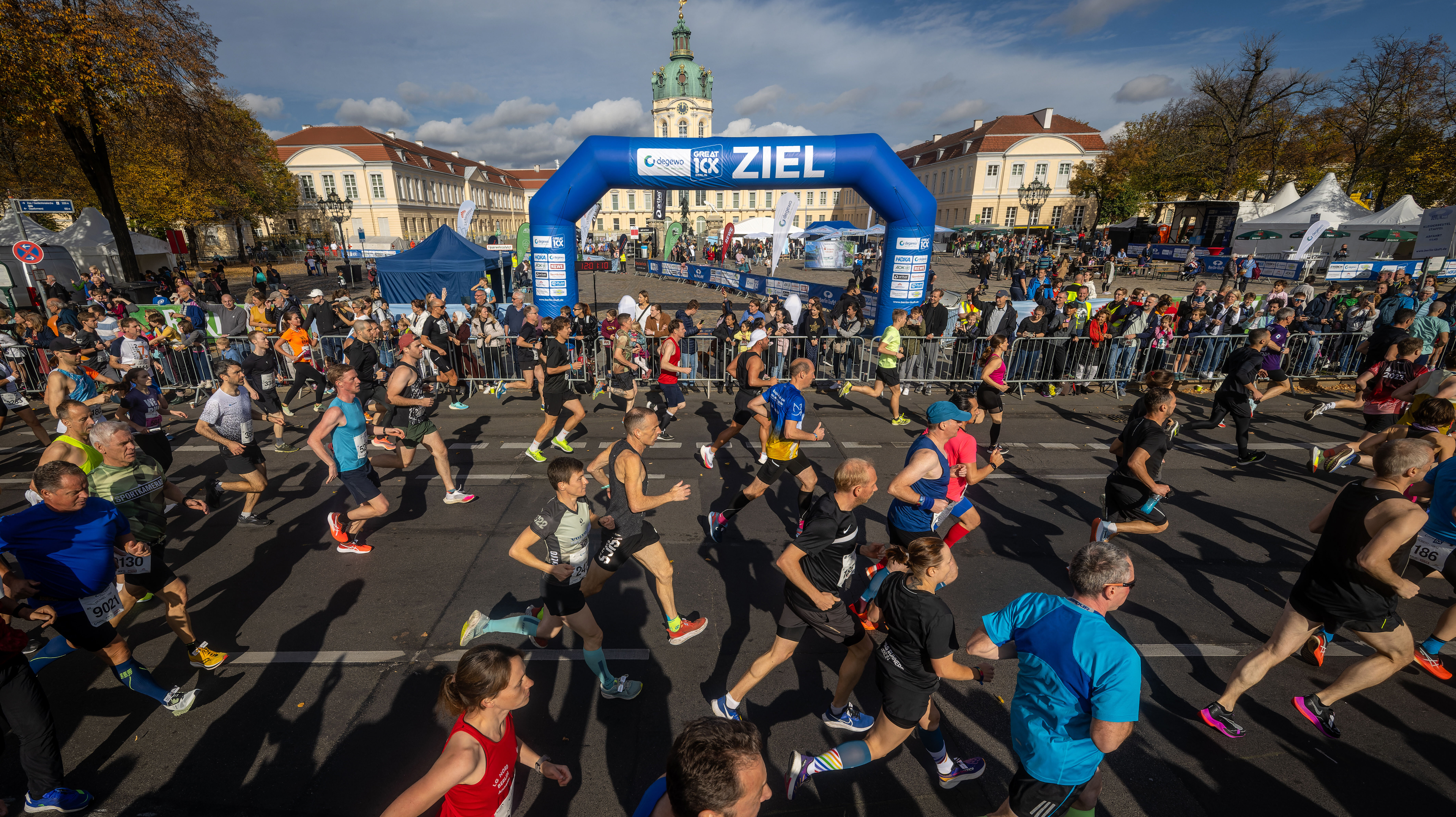 Läuferinnen und Läufer passieren Zielbogen bei Stadtlauf.