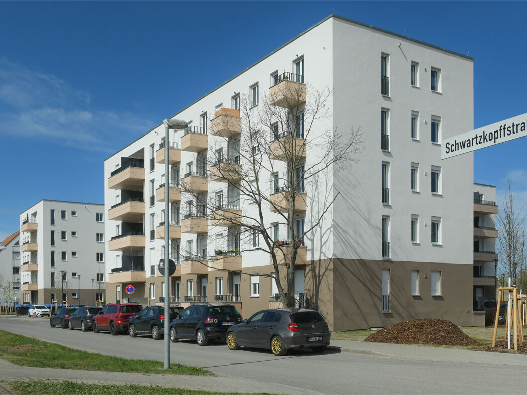 Straßenansicht degewo-Neubau Schwartzkopffstraße 20 bis 28 mit Straßenschildern rechts im Vordergrund.