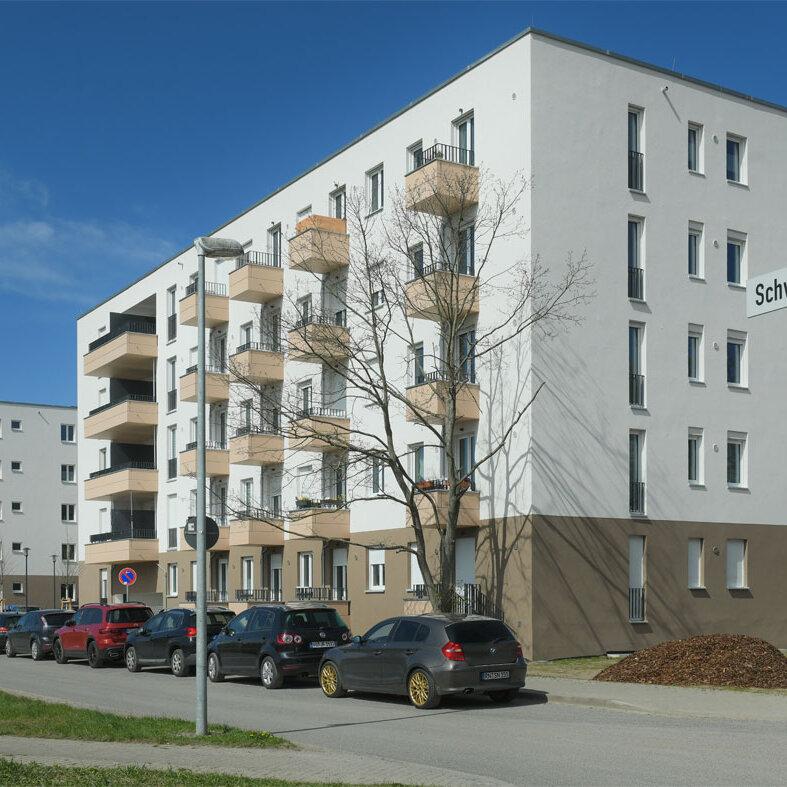Straßenansicht degewo-Neubau Schwartzkopffstraße 20 bis 28 mit Straßenschildern rechts im Vordergrund.