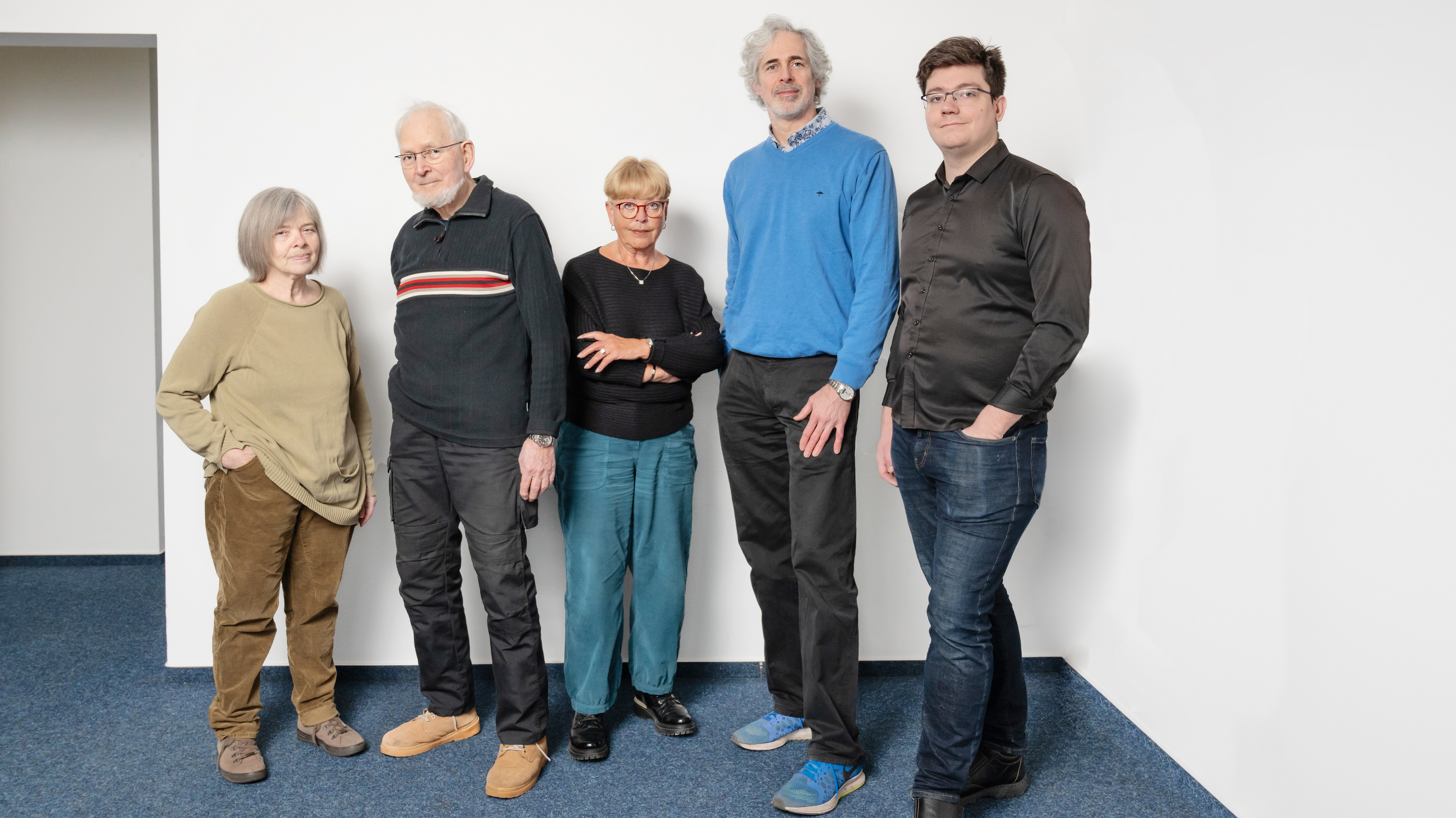 Gruppenaufnahme des Mieterbeirates Westendendsiedlung. Zwei Frauen und drei Männer stehen in einem Raum vor einer weißen Wand und blicken in die Kamera.