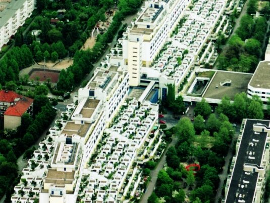 Luftbild auf das ganze lange weiße Gebäude über der Autobahn