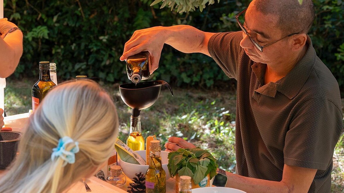 Ein Mann schenkt Wein ein, Essen steht auf einem Tisch