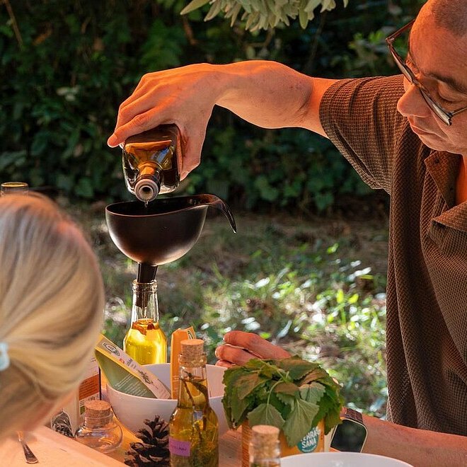 Ein Mann schenkt Wein ein, Essen steht auf einem Tisch
