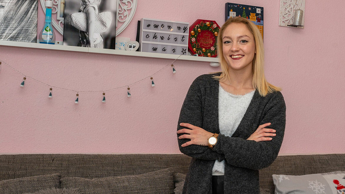 Blonde Frau lächelt mit verschränkten Armen