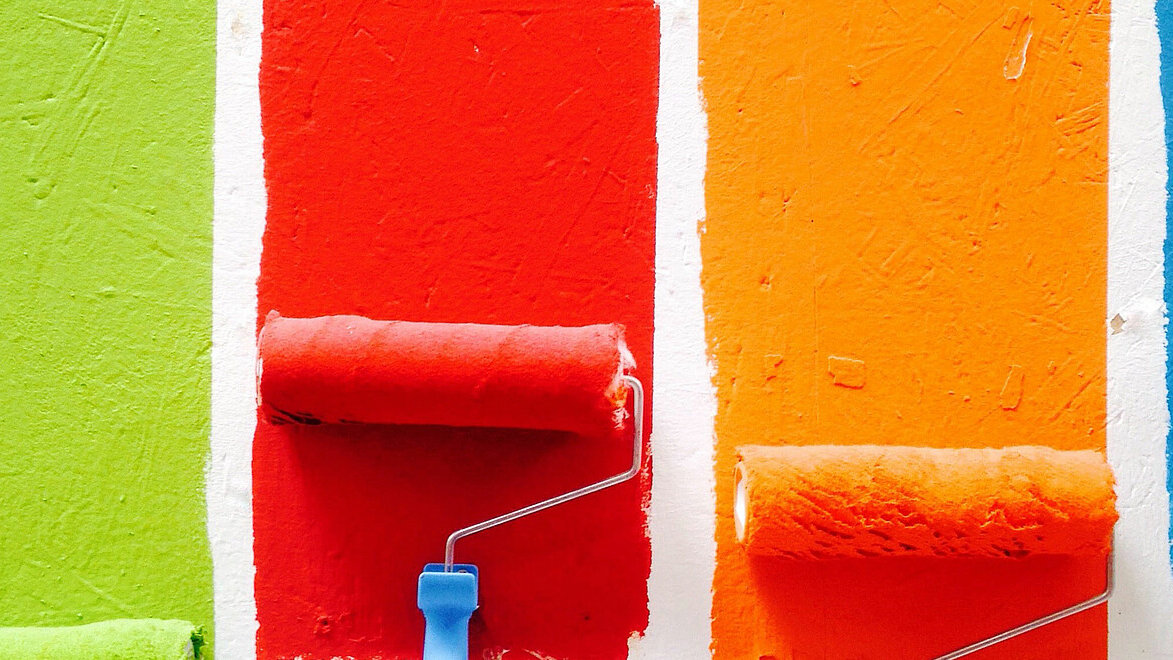 Vier Malerrollen mit bunten Farben