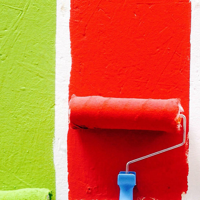 Vier Malerrollen mit bunten Farben