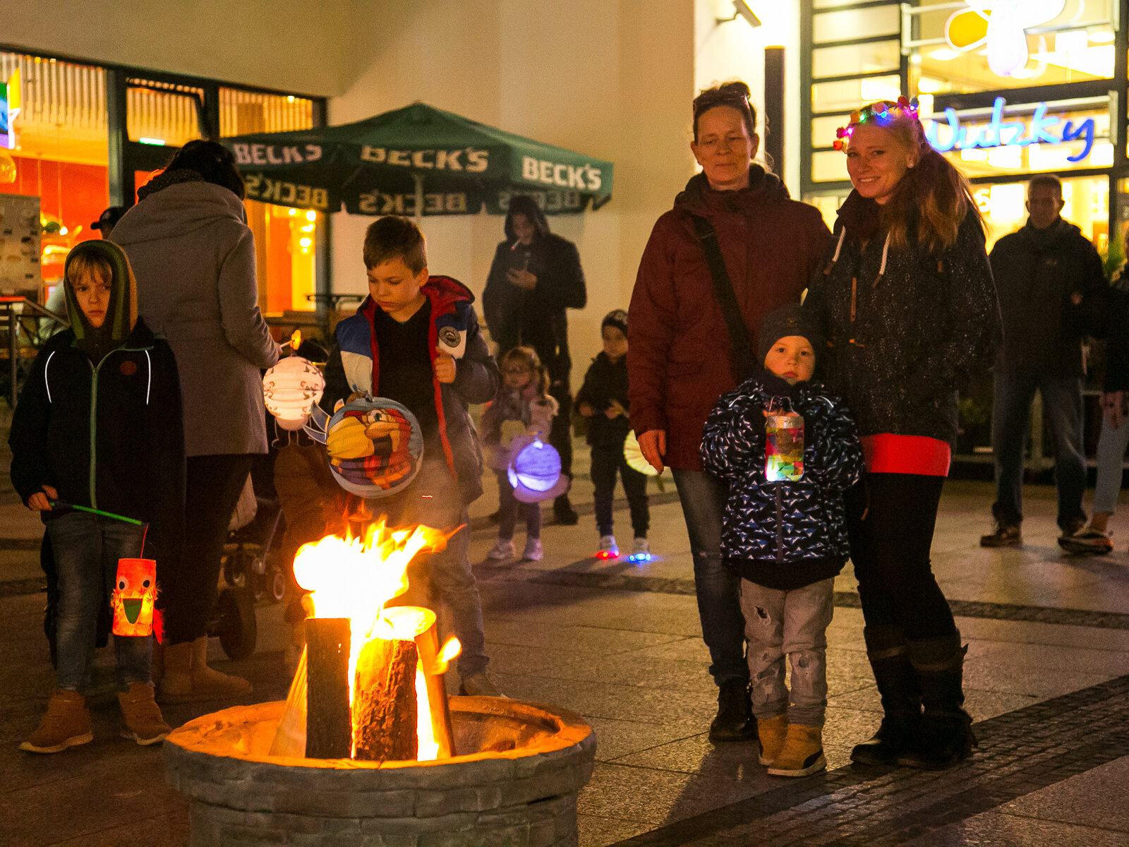 Um ein Feuer stehen Menschen herum.