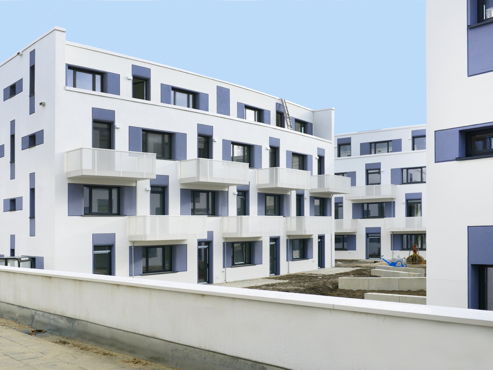 Außenansicht degewo-Neubau Joachimstraße 8 A bis E mit niedriger Mauer im Vordergrund.