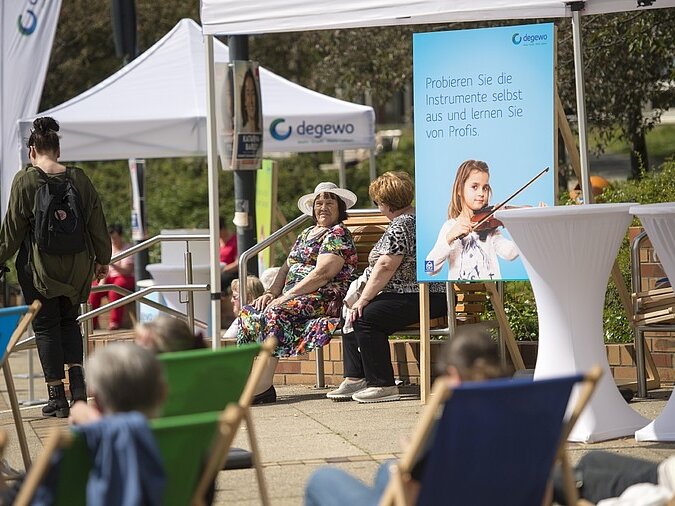 Blick auf Liegestühle und Bänke mit Zuschauern