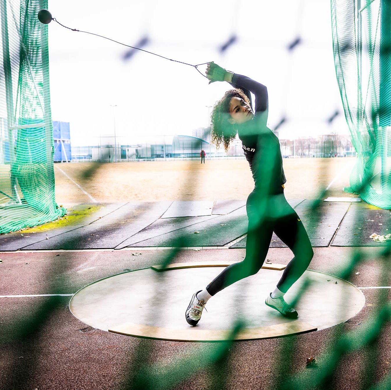 Eine junge Hammerwerferin dreht sich im Kreis und ist kurz davor, den Hammer zu werfen.