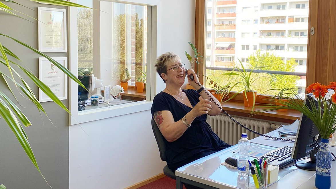 Die Mitarbeiterin von SOPHIA beantwortet einen Anruf glücklich. 