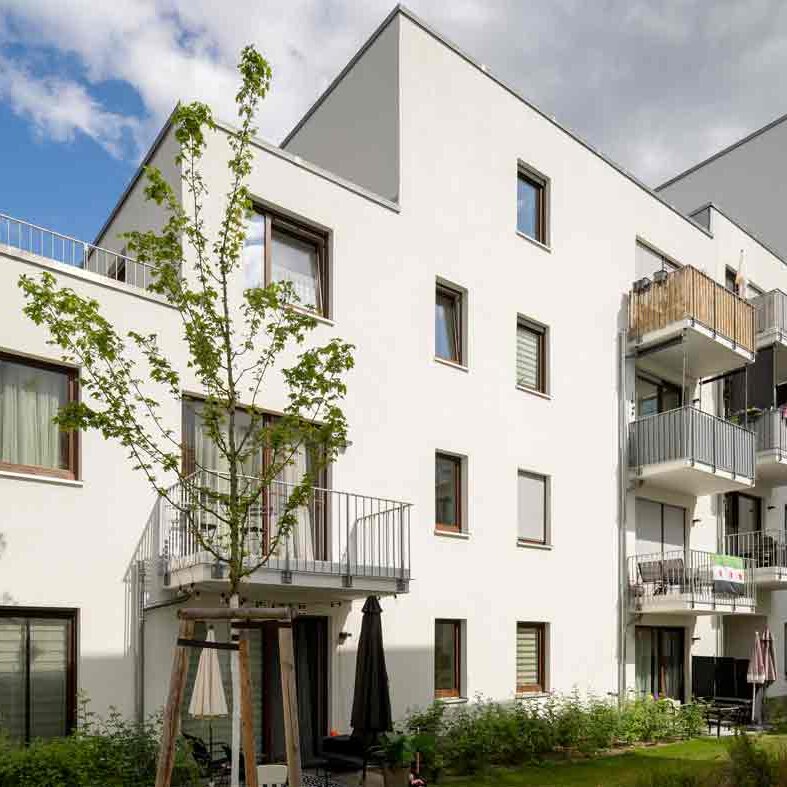 Außenansicht degewo-Neubau Glasower Straße 3 A mit neu gepflanztem Baum im Vordergrund.