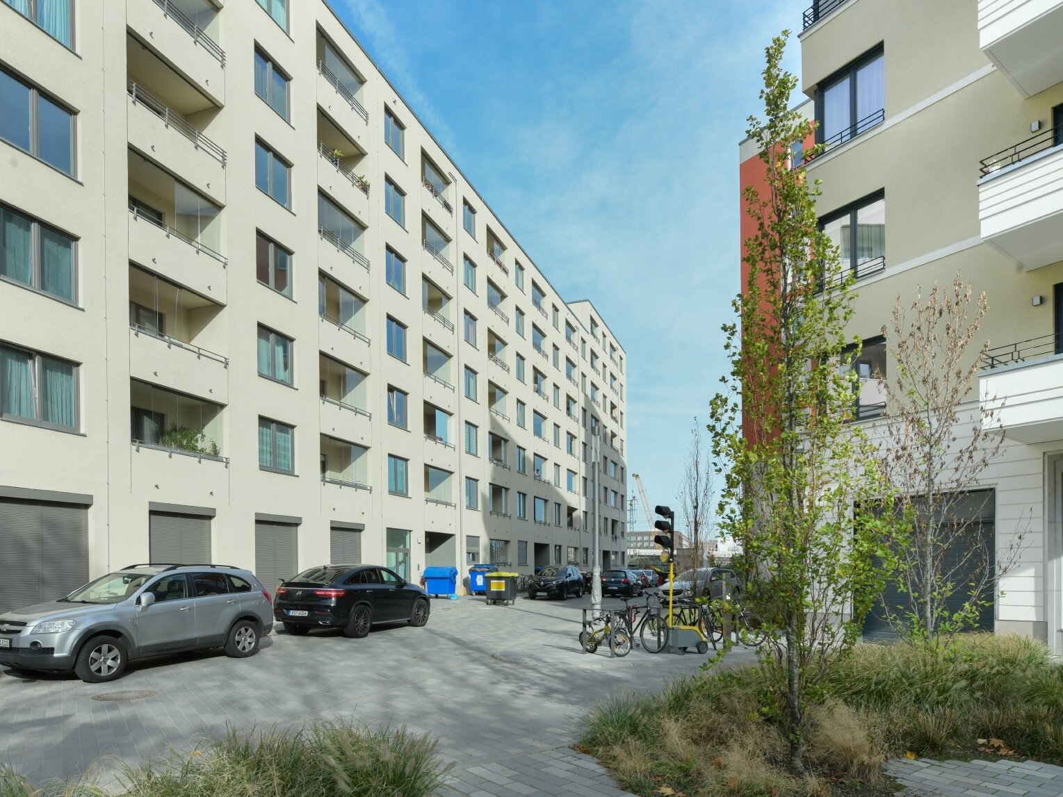 Außenansicht degewo-Neubau Klara-Franke-Straße 1 bis 7 mit Pflanzen und rechts jungen Bäumen im Vordergrund.