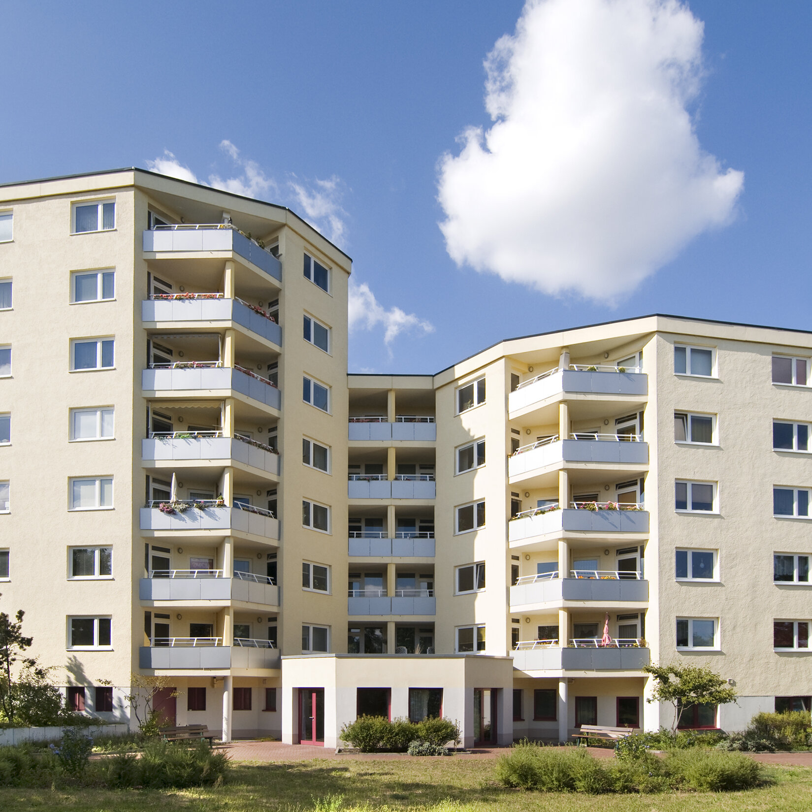 Blick auf mehrere Wohnhäuser im gleichen Stil mit Balkonen und einem großen Eingangsbereich