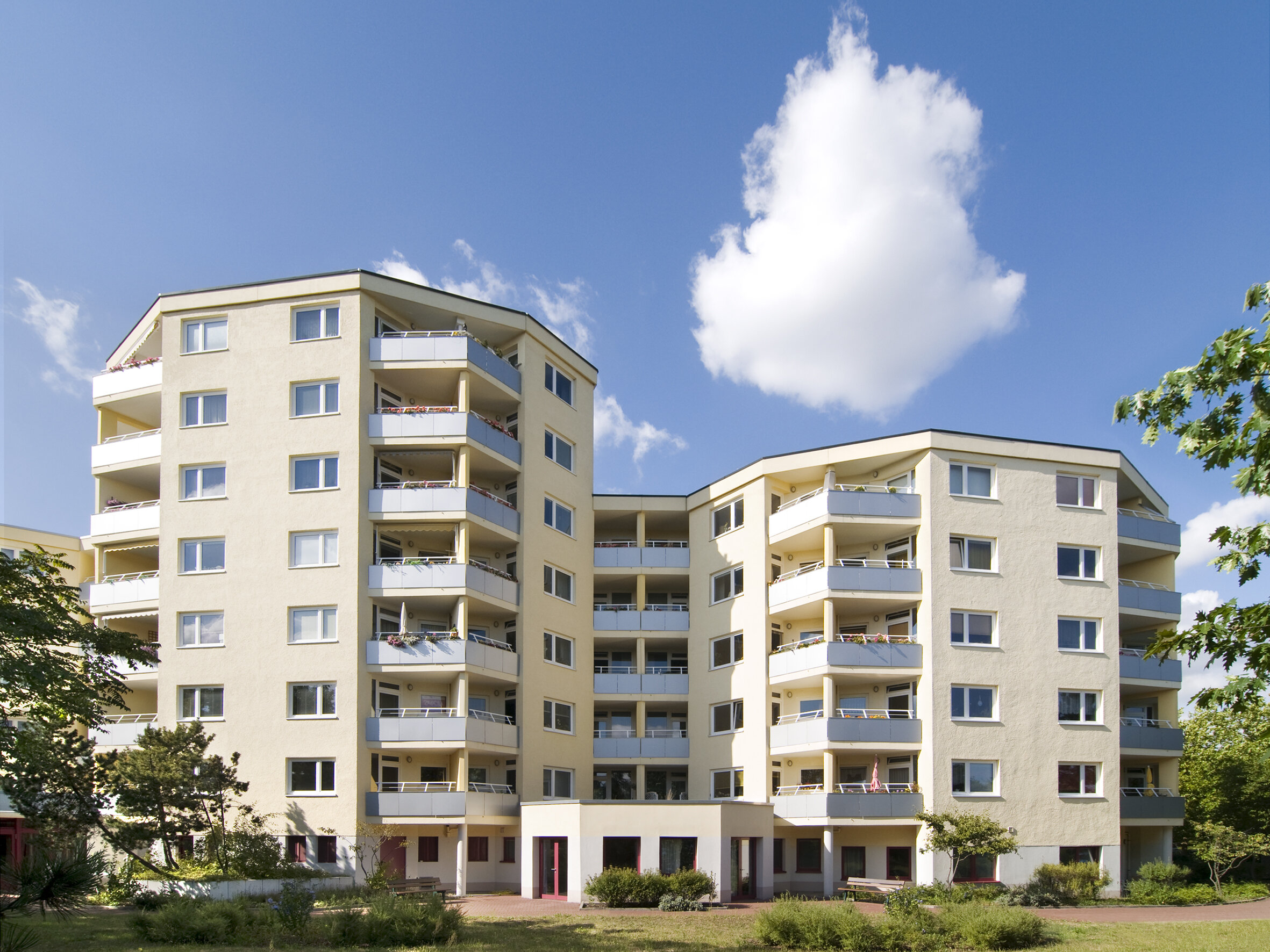 Blick auf mehrere Wohnhäuser im gleichen Stil mit Balkonen und einem großen Eingangsbereich