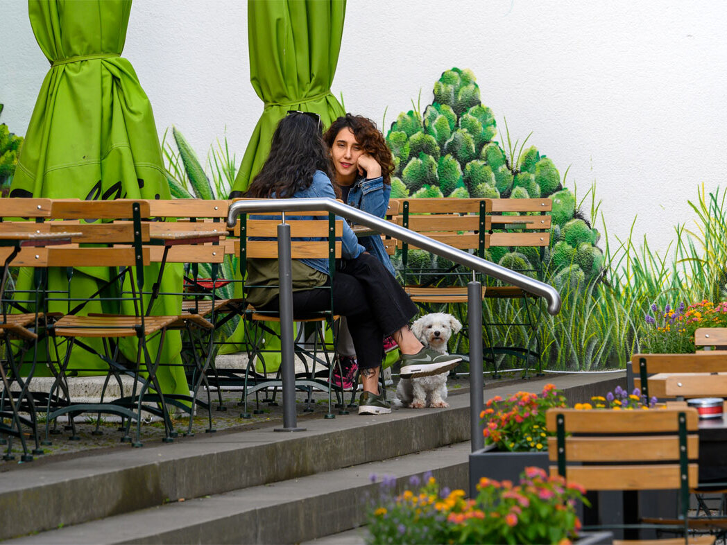 Zwei Frauen sitzen im Straßencafe am Tisch