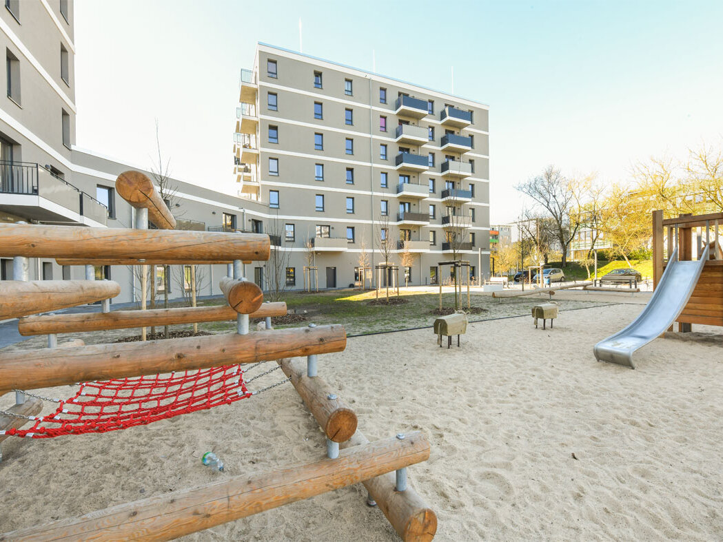Außenansicht degewo-Neubau Mehrower Allee 28 und 30: Rückseite mit Spielplatz im Vordergrund.