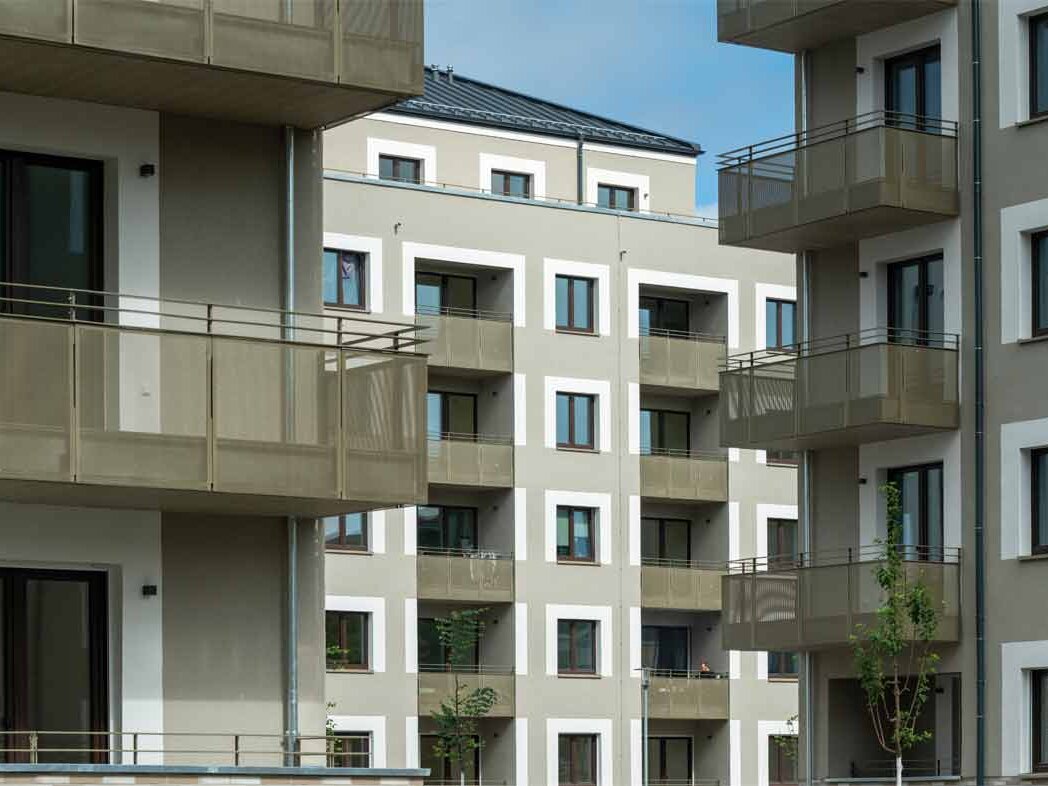 Außenansicht degewo-Neubau Falkenstraße Adlerstraße: drei Fassaden mit Balkonen.