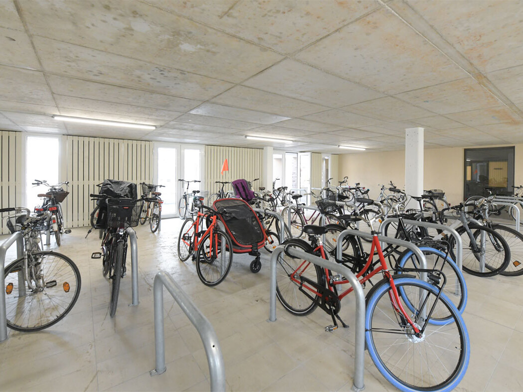Innenansicht Fahrradhaus degewo-Neubau Pulsstraße 13 und 15 mit Fahrradständern und Rädern.