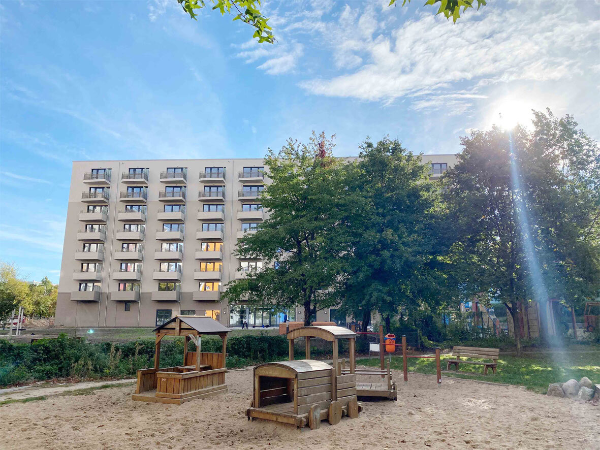 Außenansicht degewo-Neubau Venusstraße 28 mit Spielplatz im Vordergrund.