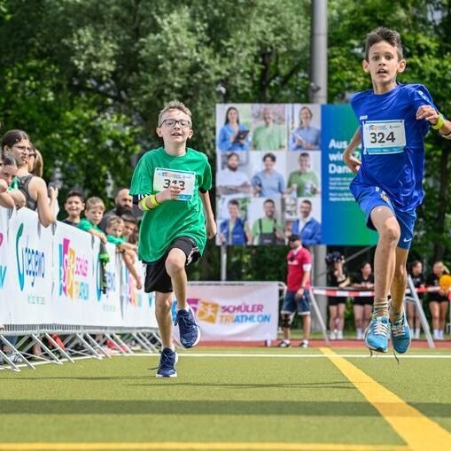 Teilnehmende am degewo-Schülertriathlon beim Zieleinlauf im degewo-Stadion in der Gropiusstadt