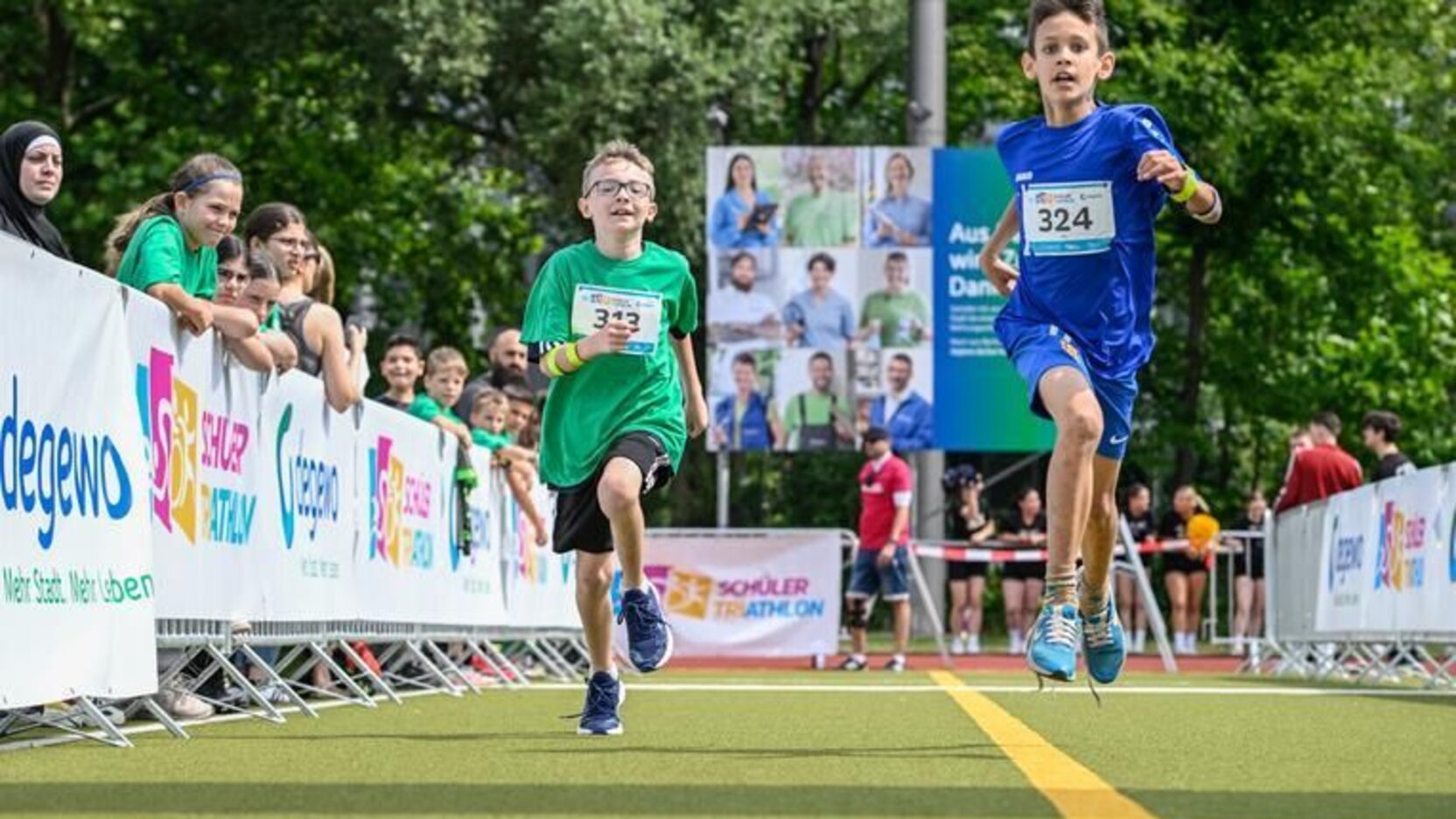 Teilnehmende am degewo-Schülertriathlon beim Zieleinlauf im degewo-Stadion in der Gropiusstadt