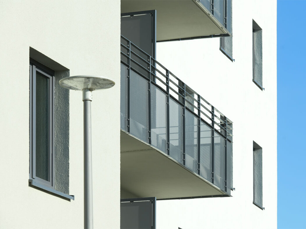 Außenansicht degewo-Neubau Mahlower Straße 2 bis 4 A: Fassade mit Balkon und Straßenlaterne davor..