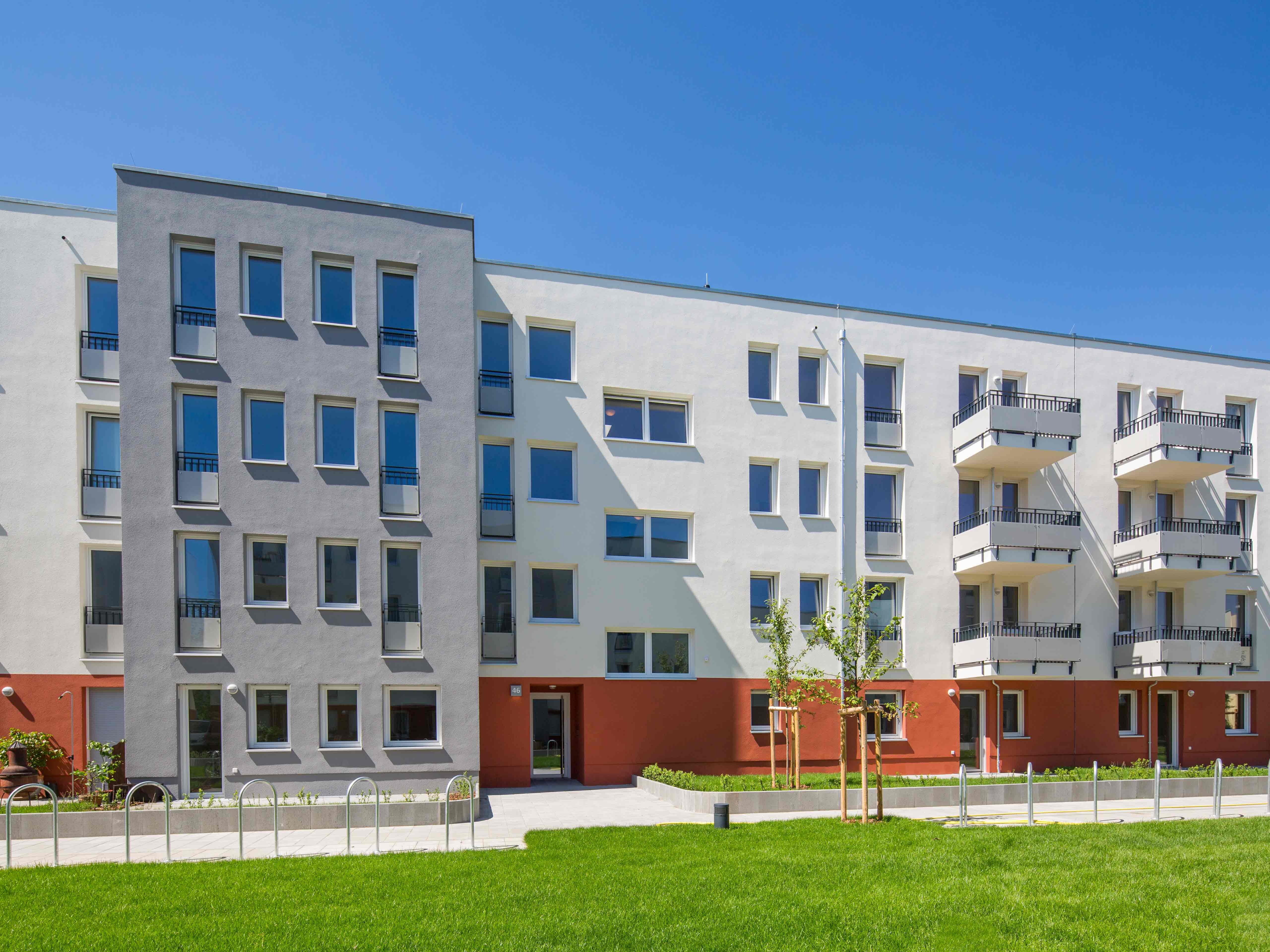 Außenansicht degewo-Neubau Elly-Heuss-Knapp-Straße 46 mit Rasenfläche im Vordergrund.