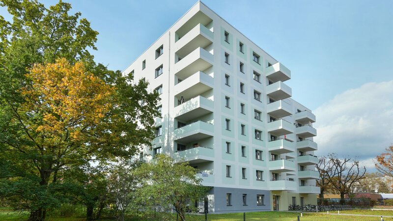 Außenansicht degewo-Neubau Tramper Weg 6 mit Rasenfläche im Vordergrund.