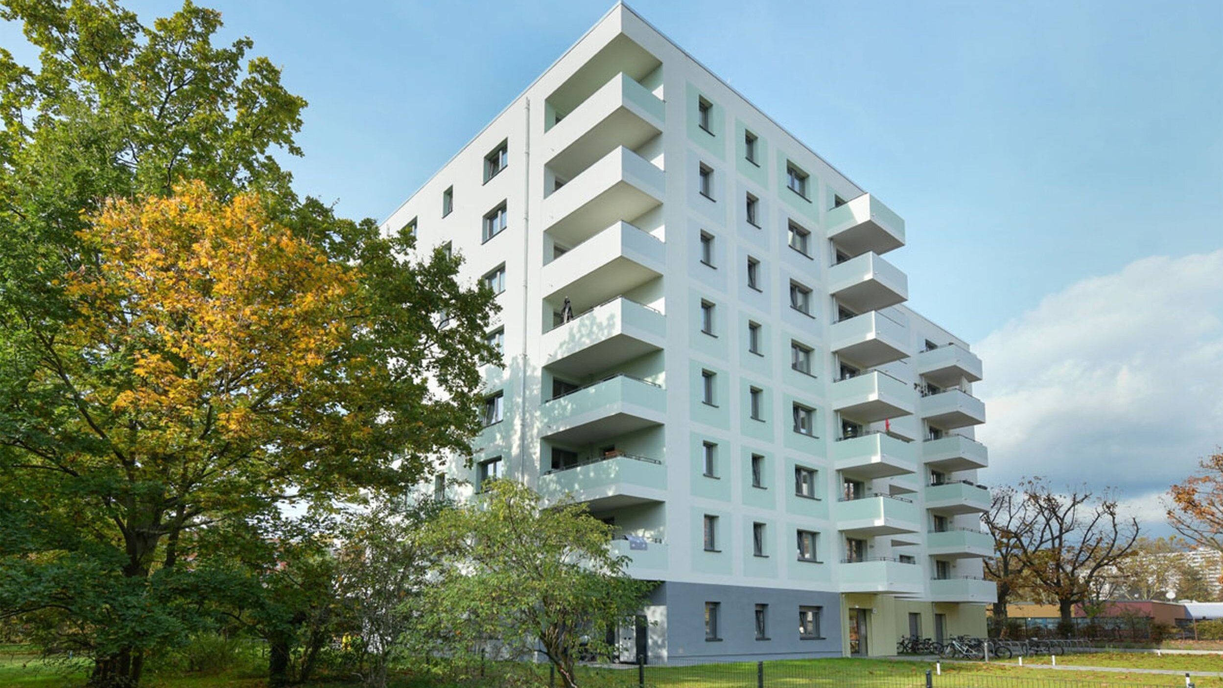 Außenansicht degewo-Neubau Tramper Weg 6 mit Rasenfläche im Vordergrund.