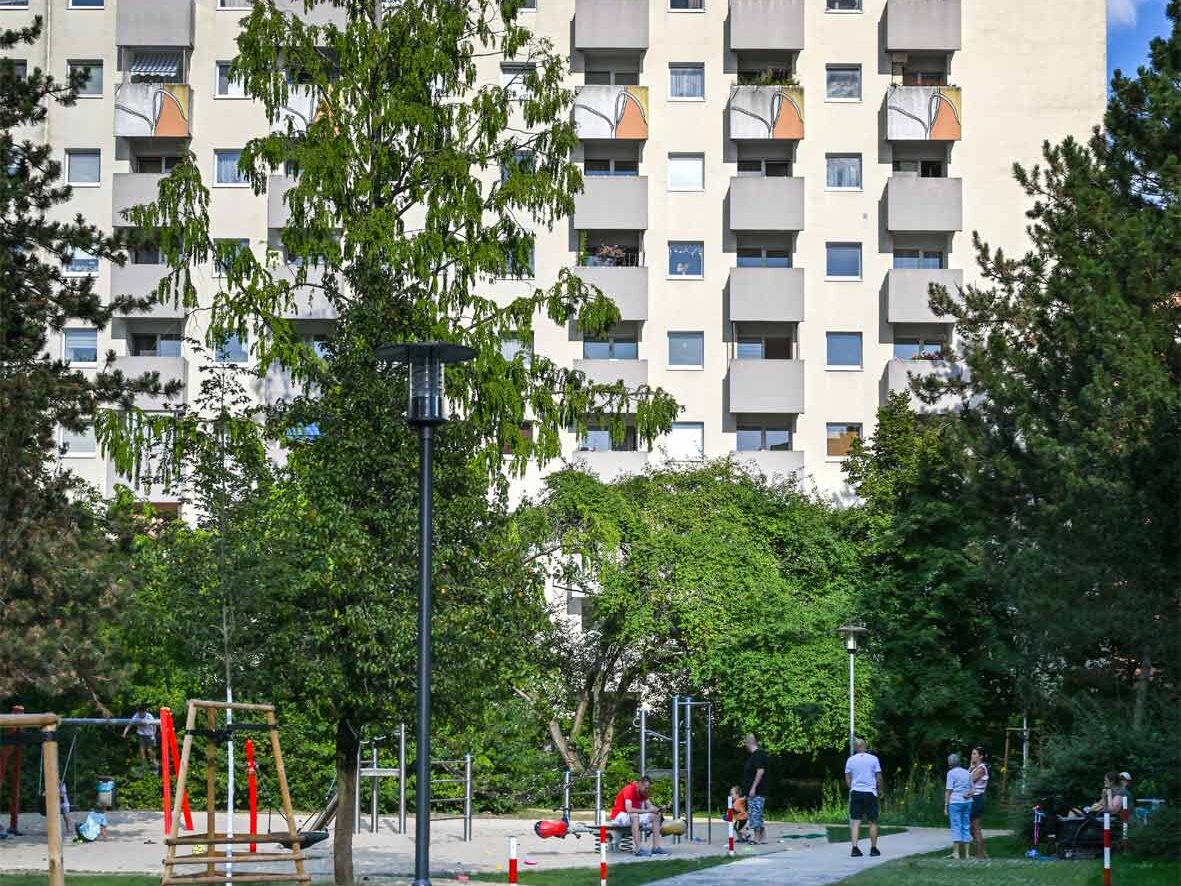 Außenansicht degewo-Neubau Borgenhagenweg 43A: Hofseite mit Spielplatz, gepflasterter Weg im Vordergrund.