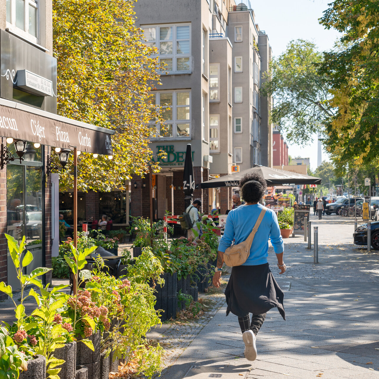 Geschäfte entlang der Brunnenstrasse im Somme. Eine Frau spaziert daran vorbei.