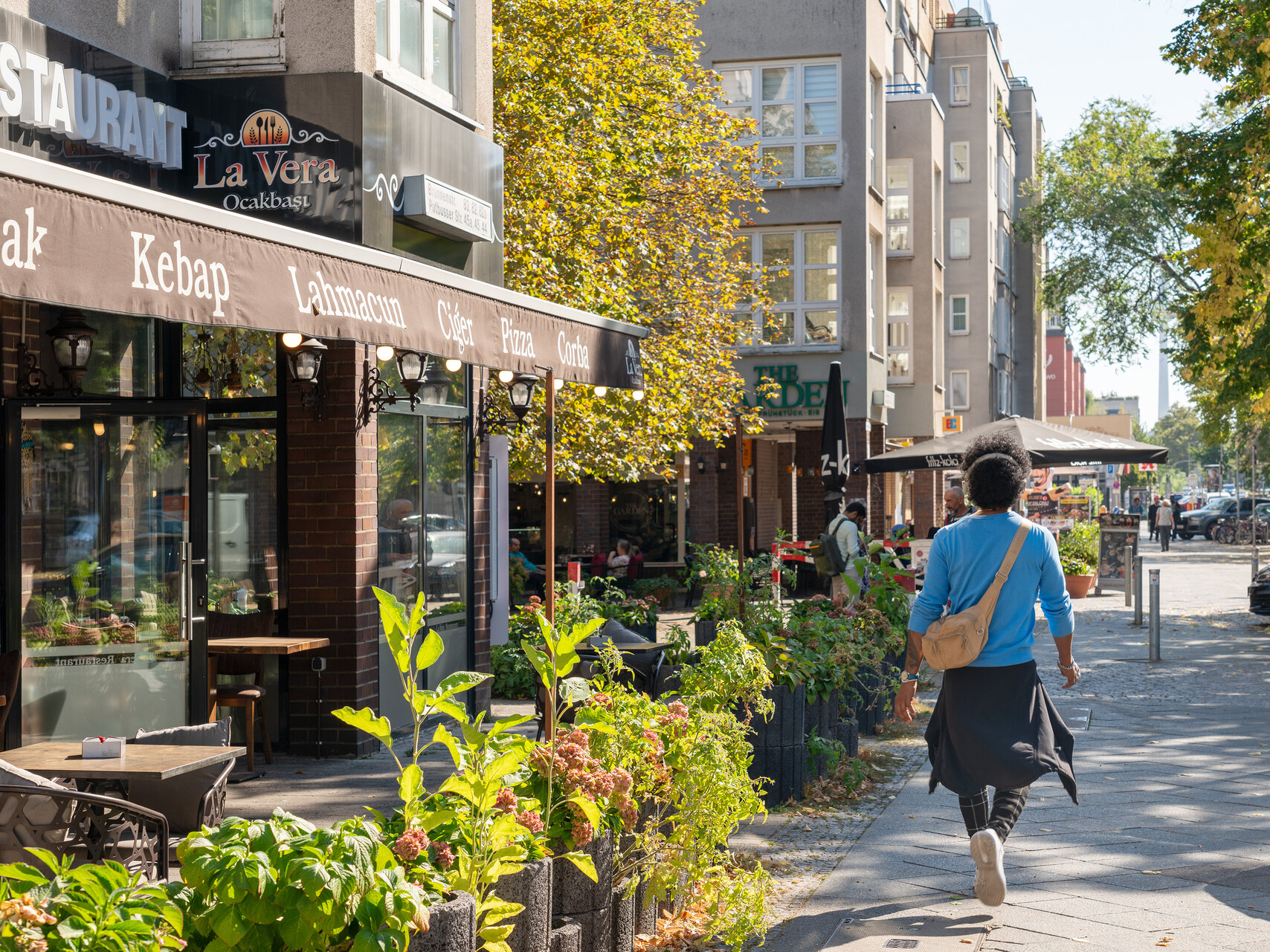Geschäfte entlang der Brunnenstrasse im Somme. Eine Frau spaziert daran vorbei.
