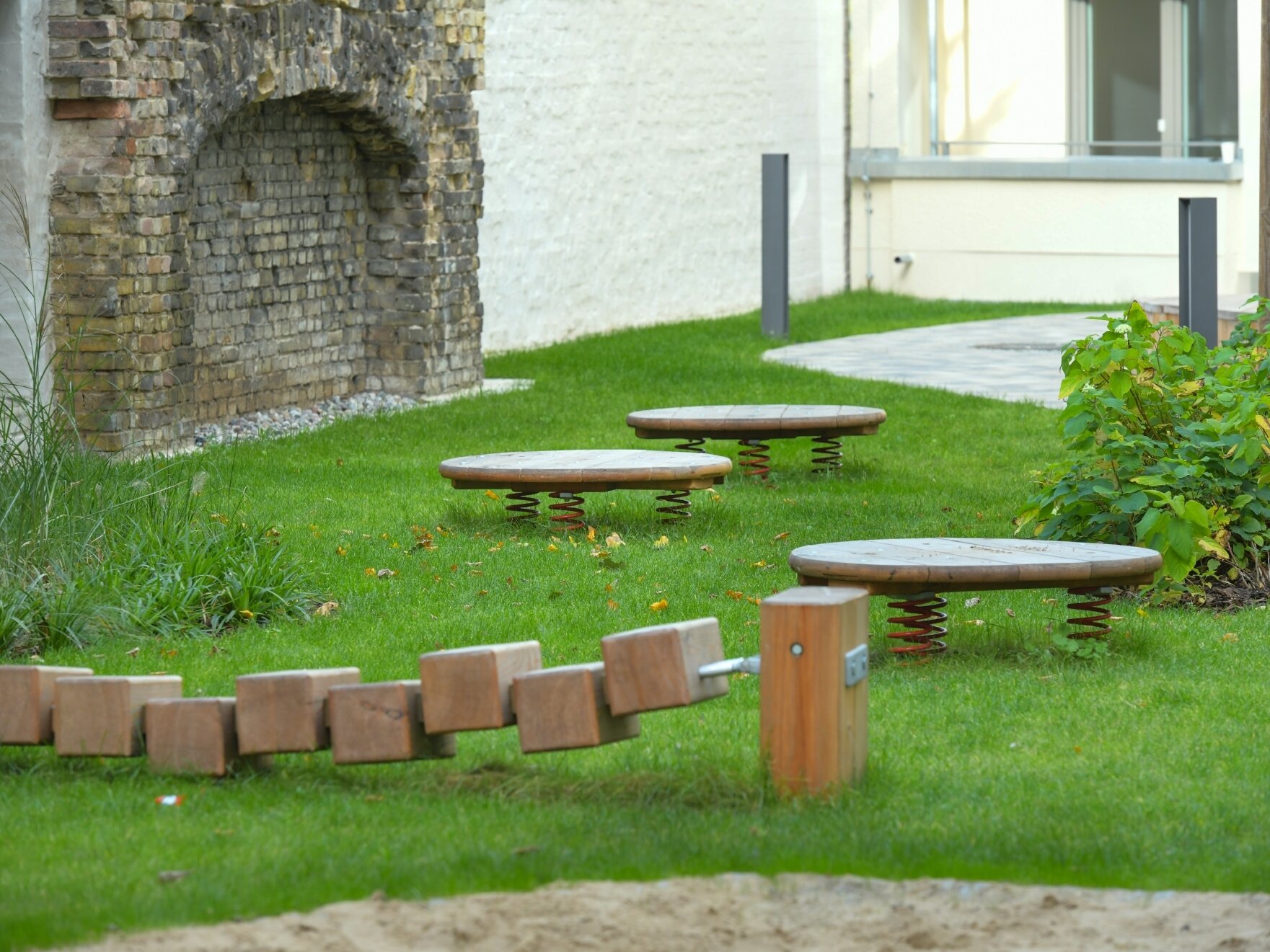 Außenansicht degewo-Neubau Klara-Franke-Straße 1 bis 7: Hofseite mit Rasenspielplatz im Vordergrund.