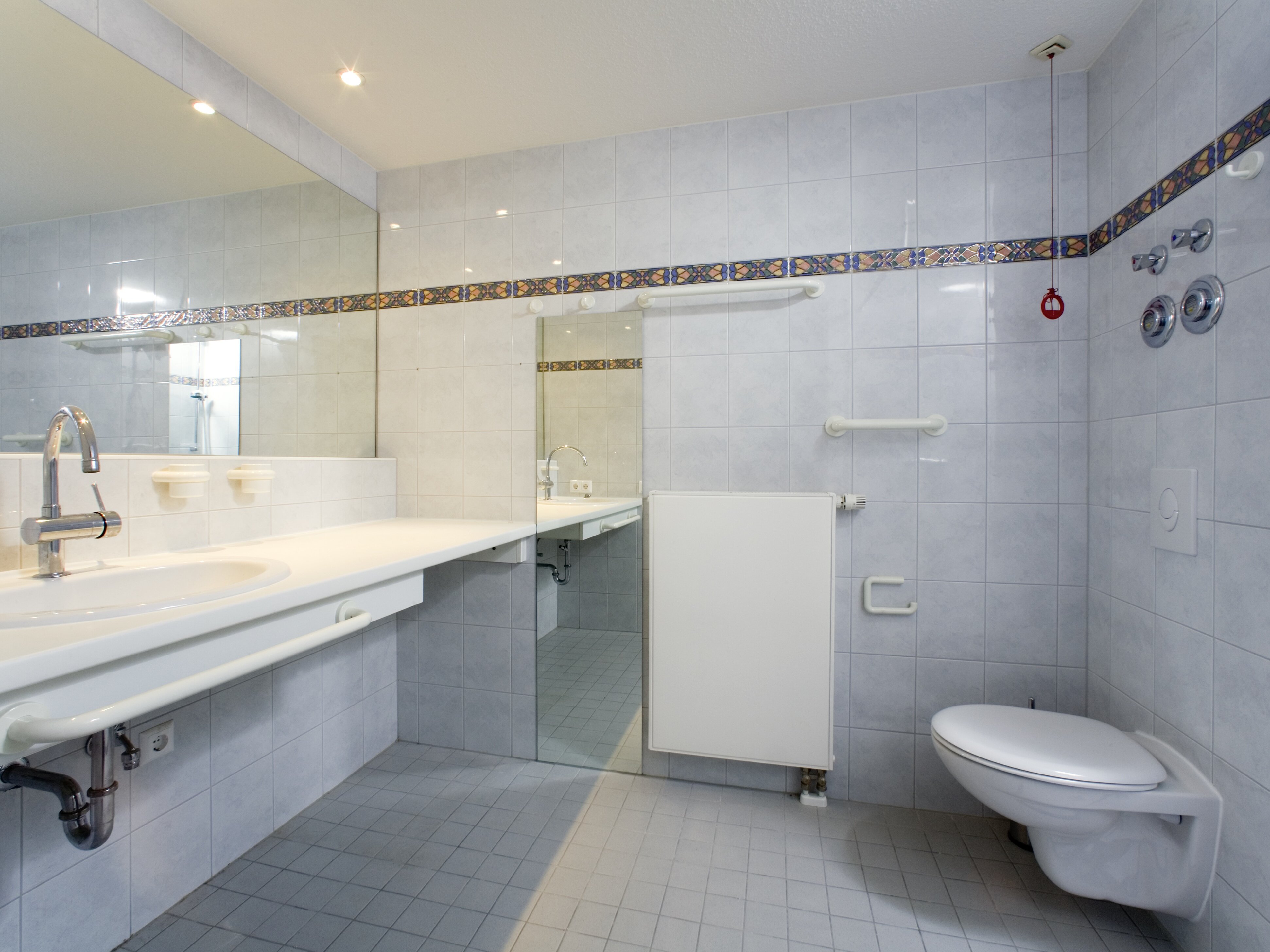 Badezimmer mit Waschbecken und Toilette in weiß