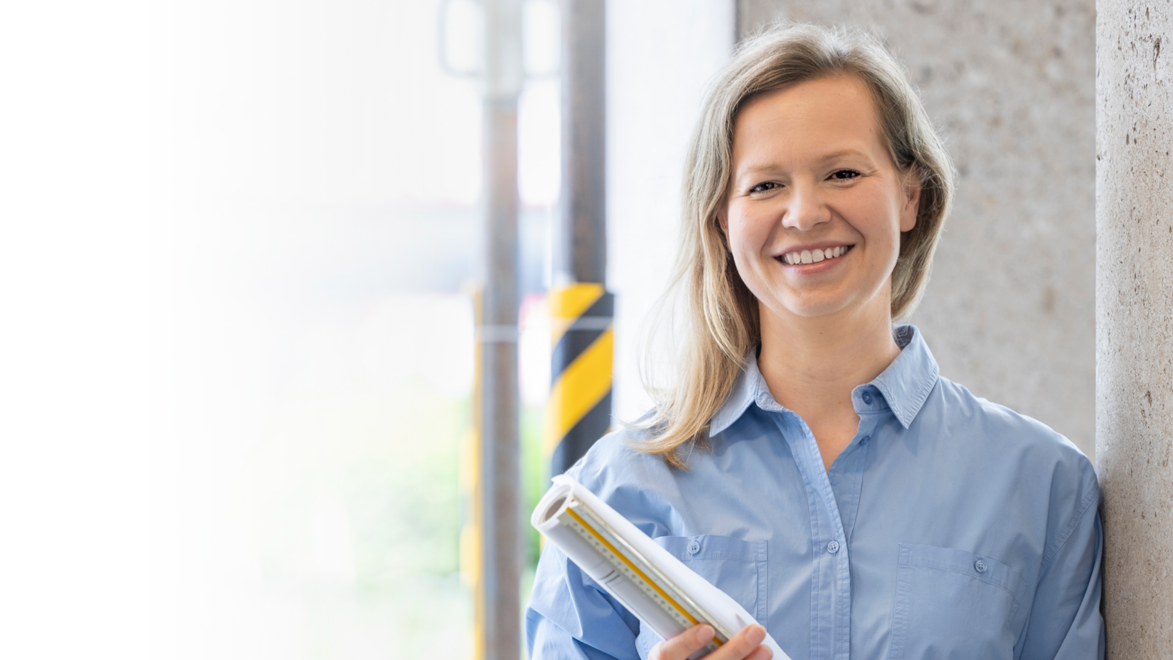 Stolze Architektin mit einem Bauplan in den Händen