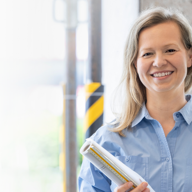 Stolze Architektin mit einem Bauplan in den Händen