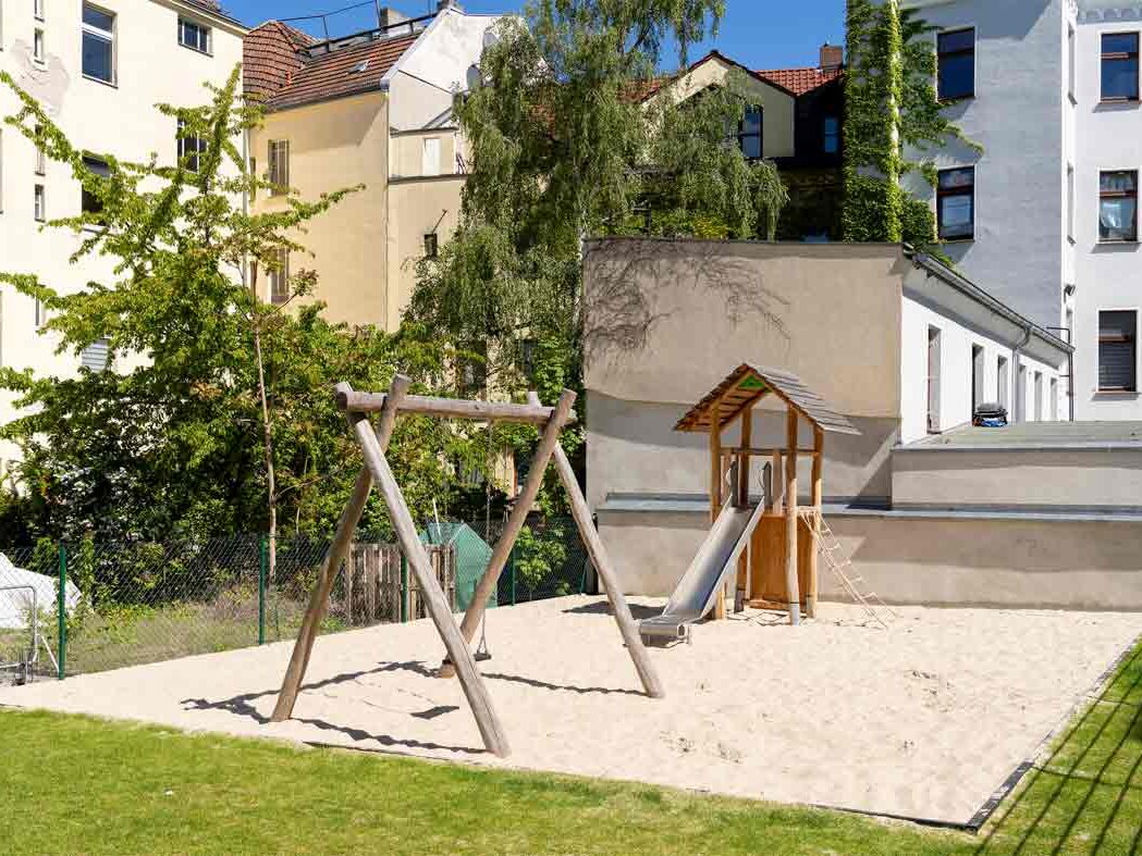 Außenansicht degewo-Neubau Glasower Straße 3 A mit Spielplatz im Vordergrund.