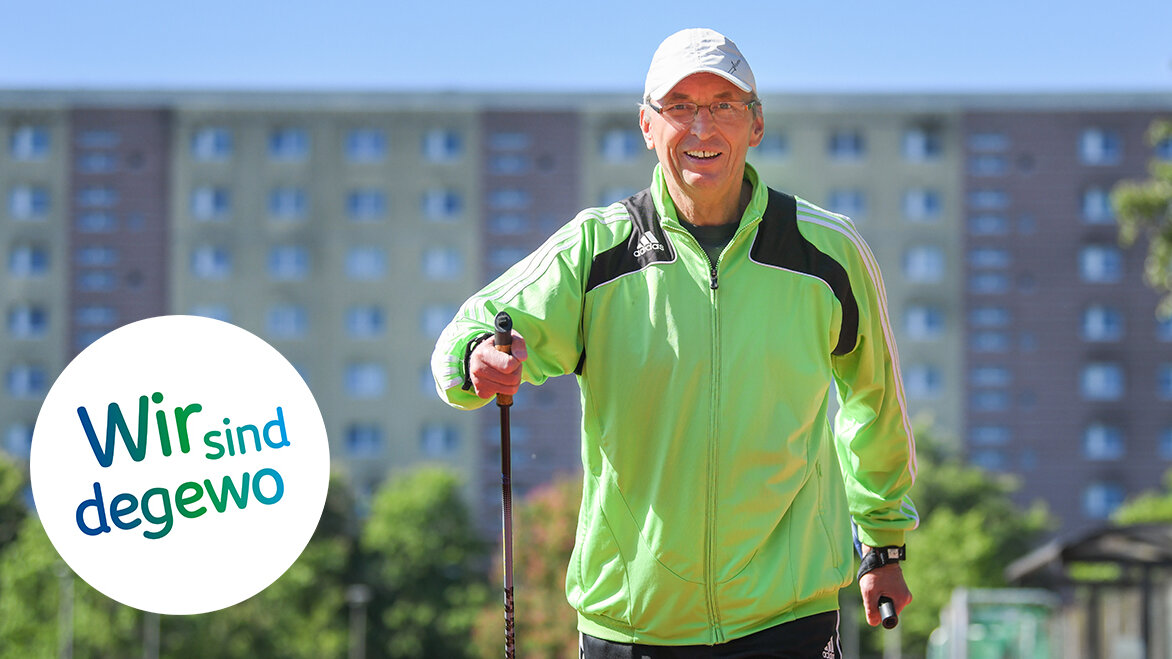 Ein Mann in Sportbekleidung mit Walking-Stöcken. Im Hintergrund befinden sich Wohnhäuser.