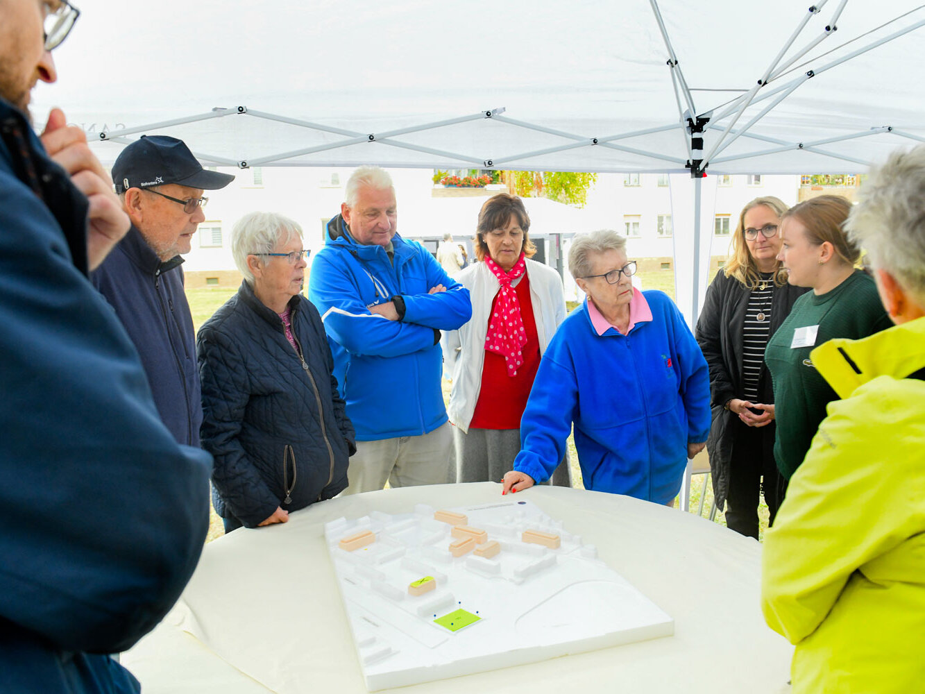 Mehrere Personen stehen um einen Tisch auf dem ein Modell steht.