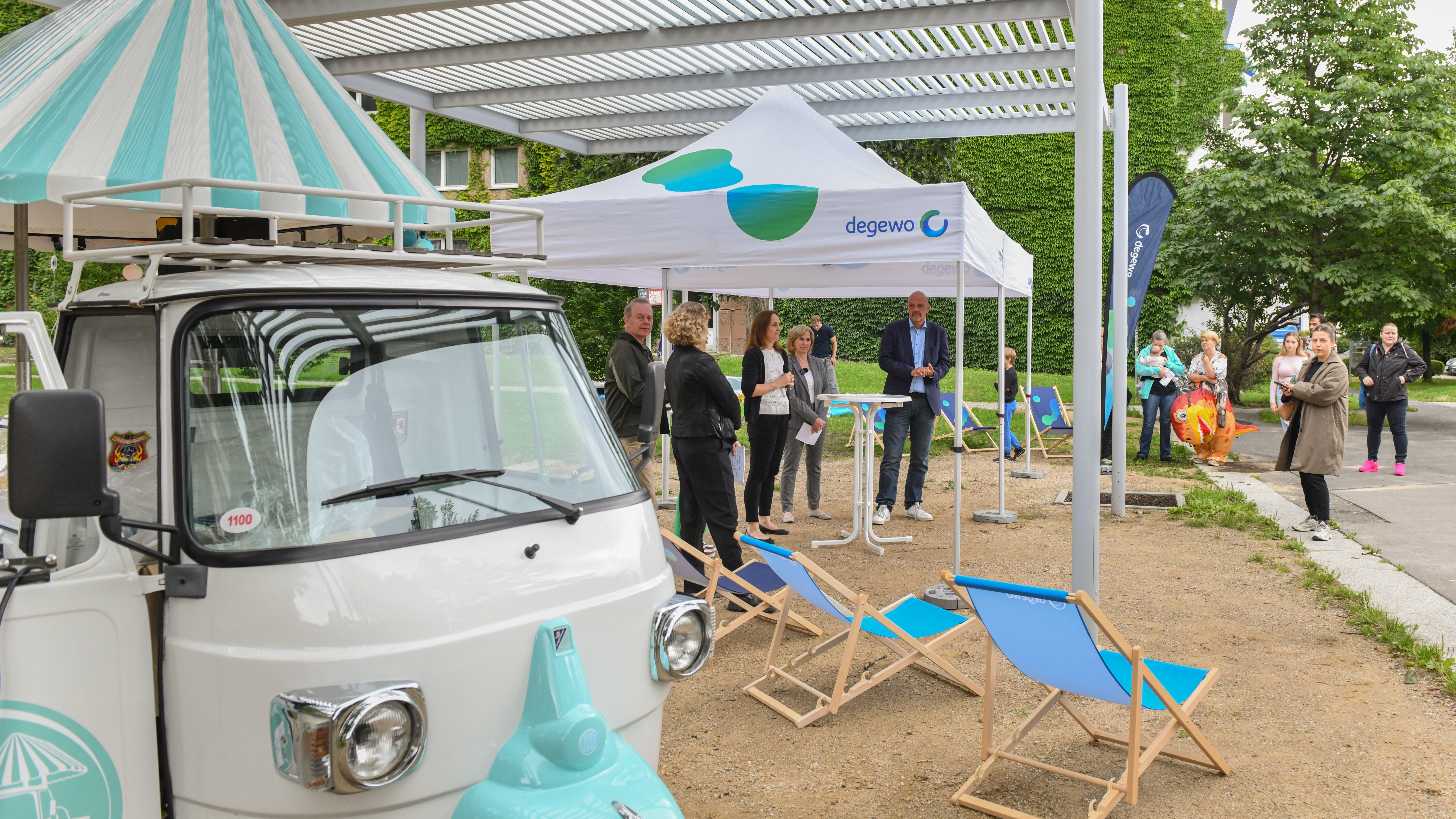 Informationsstand mit Pavillon und Sitzstühlen im Hof.