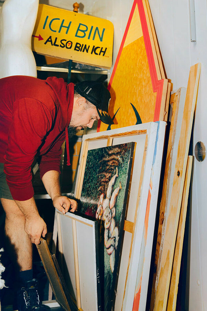 Aufnahmen von dem Künstler Marc Pospiech. Er trägt einen roten Kapuzenpullover und einen schwarze Kappe